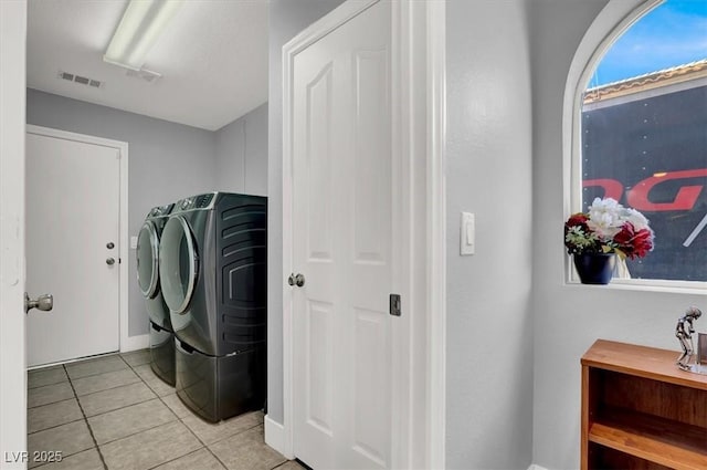 washroom with washer and clothes dryer and light tile patterned floors