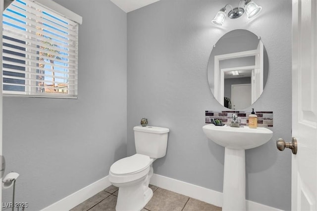 bathroom featuring toilet, tile patterned floors, and sink