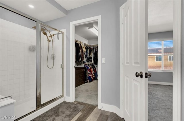 bathroom with a shower with shower door and hardwood / wood-style floors