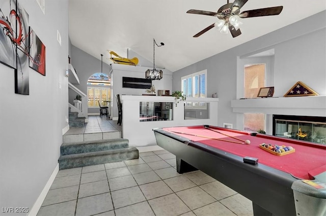 game room with lofted ceiling, light tile patterned flooring, ceiling fan with notable chandelier, and billiards