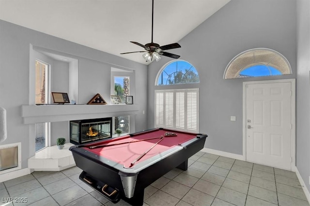 playroom with pool table, a multi sided fireplace, ceiling fan, lofted ceiling, and light tile patterned flooring