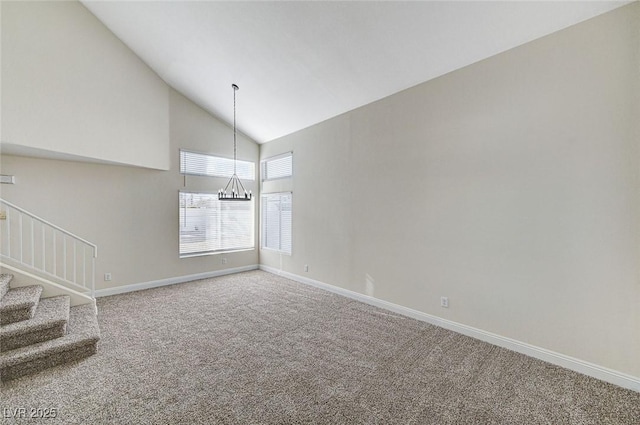 unfurnished room featuring high vaulted ceiling, an inviting chandelier, and carpet flooring