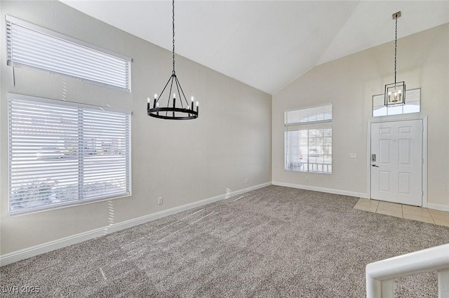 entryway with a notable chandelier, carpet floors, and vaulted ceiling