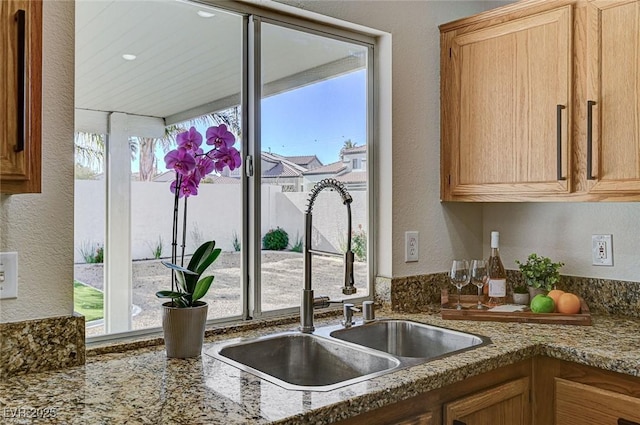 kitchen with light stone counters and sink