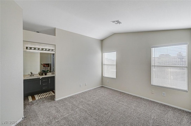 unfurnished bedroom with vaulted ceiling, carpet flooring, and sink