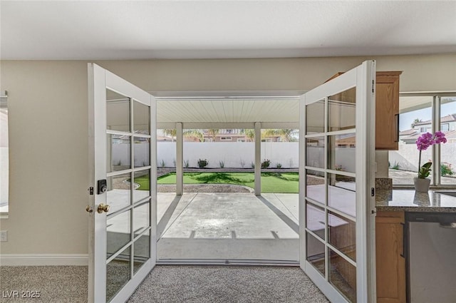 doorway to outside featuring french doors, a wealth of natural light, and carpet