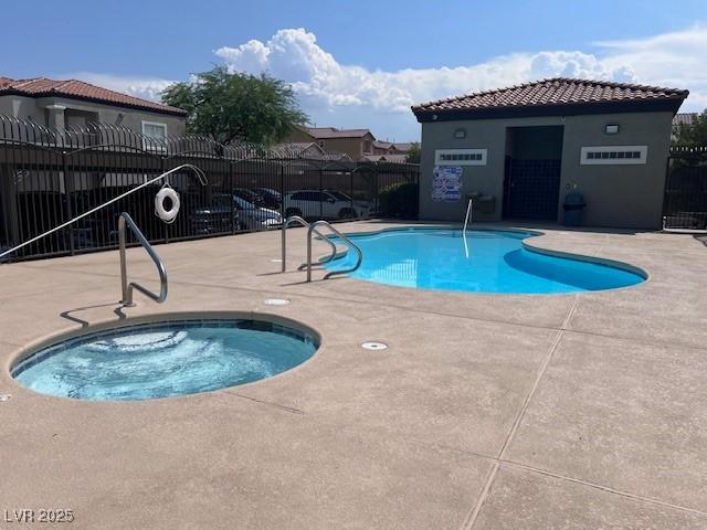 view of swimming pool featuring a community hot tub and a patio