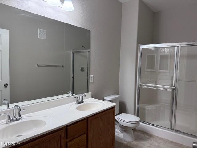 bathroom with toilet, a shower with door, and vanity