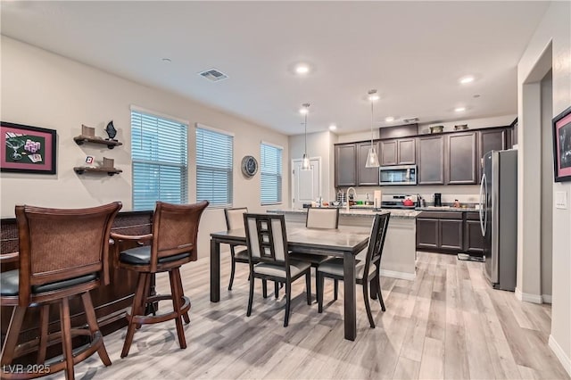 dining space with light hardwood / wood-style floors and sink