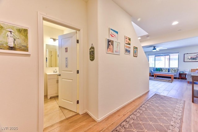 hall with sink and light hardwood / wood-style flooring