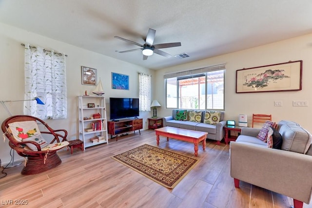 living room featuring hardwood / wood-style floors and ceiling fan