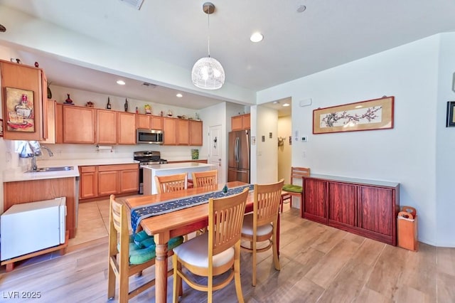 dining area featuring light wood-type flooring and sink