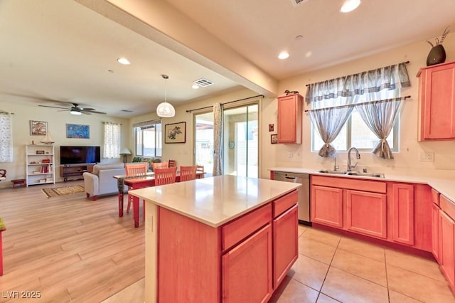 kitchen featuring dishwasher, ceiling fan, pendant lighting, a kitchen island, and sink