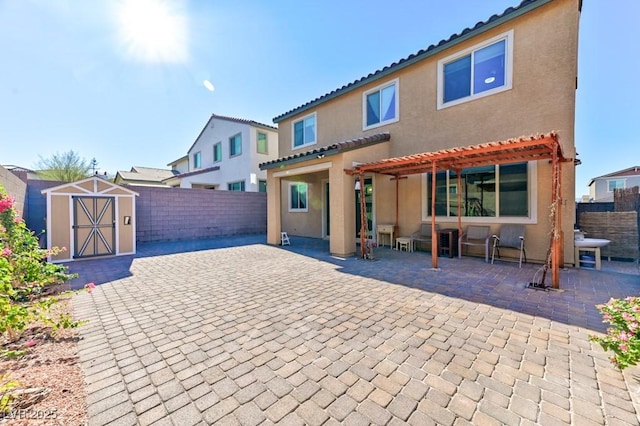 back of property with a patio area and a storage shed