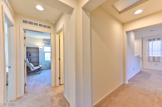 corridor featuring light colored carpet