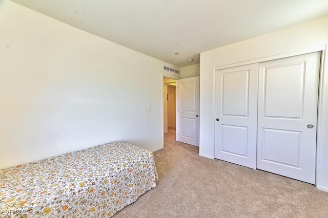 unfurnished bedroom with a closet and light carpet