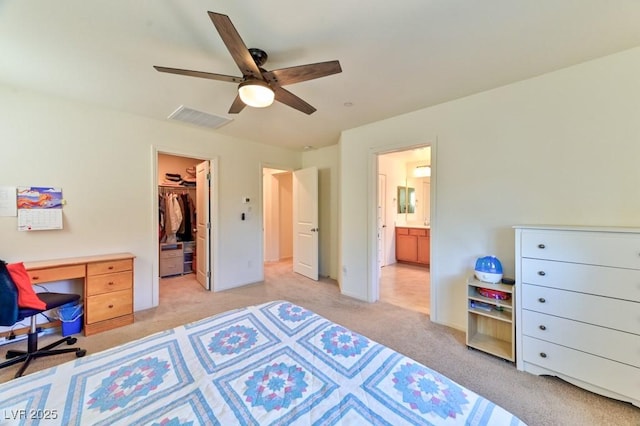 carpeted bedroom with a walk in closet, ensuite bathroom, a closet, and ceiling fan