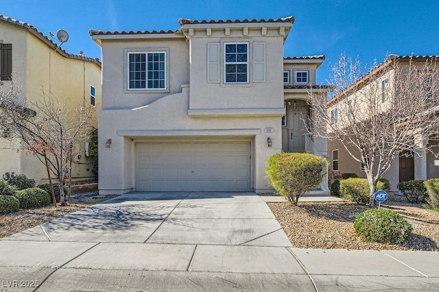 mediterranean / spanish house featuring a garage, driveway, and stucco siding