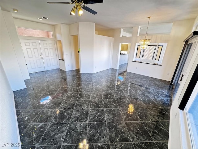 interior space with ceiling fan with notable chandelier