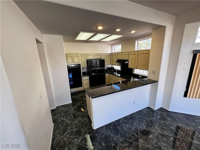 kitchen with kitchen peninsula, light brown cabinetry, and black appliances