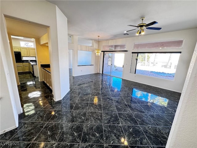 kitchen featuring ceiling fan with notable chandelier and pendant lighting