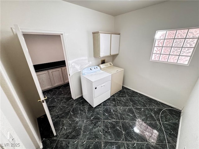 clothes washing area with washing machine and dryer and cabinets