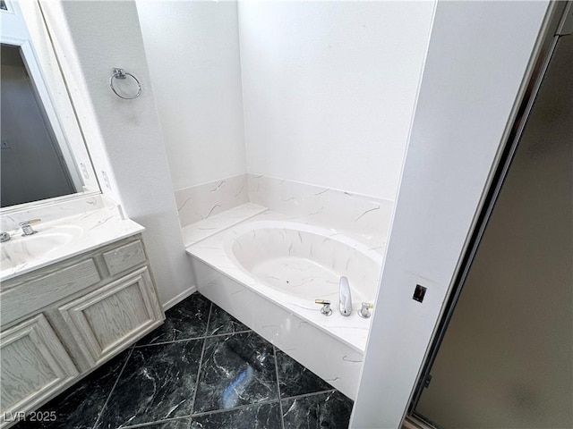 bathroom featuring vanity and a washtub