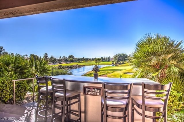 view of patio featuring exterior bar and a water view