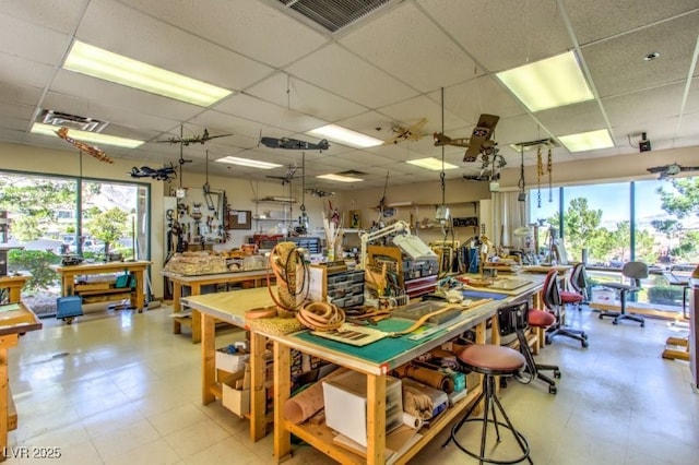 interior space with a workshop area and a paneled ceiling