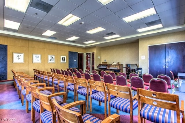 carpeted cinema featuring a paneled ceiling