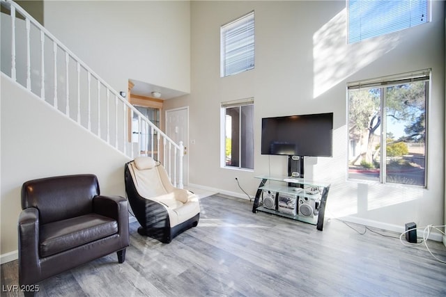 sitting room with a high ceiling and hardwood / wood-style floors