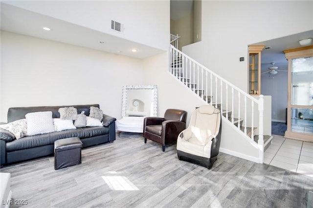 living room featuring ceiling fan and a towering ceiling