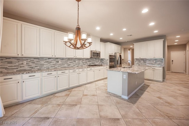 kitchen with pendant lighting, a kitchen island with sink, white cabinetry, appliances with stainless steel finishes, and sink