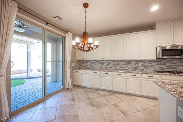 kitchen with white cabinetry, tasteful backsplash, hanging light fixtures, and appliances with stainless steel finishes