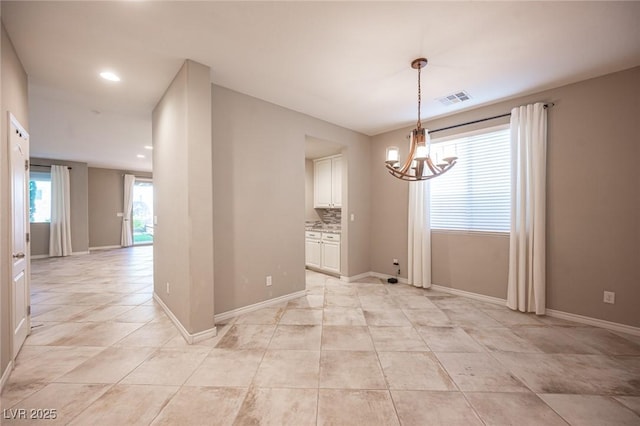 spare room with light tile patterned floors and a chandelier