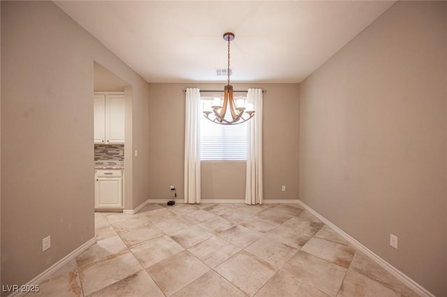 unfurnished dining area featuring a notable chandelier