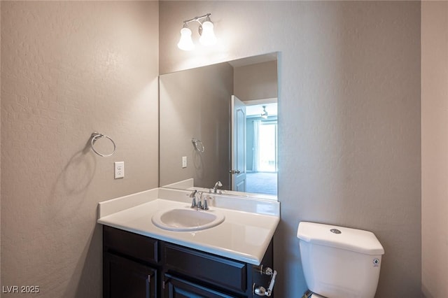 bathroom featuring ceiling fan, vanity, and toilet