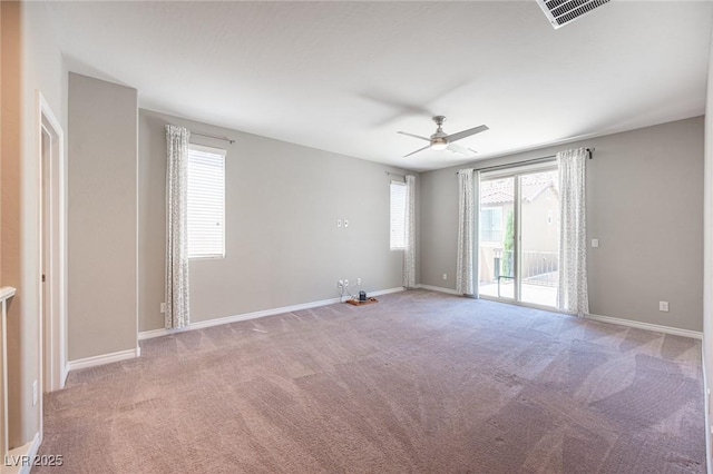 carpeted spare room featuring ceiling fan and a wealth of natural light