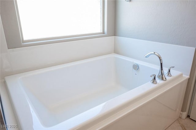 bathroom with plenty of natural light and a tub