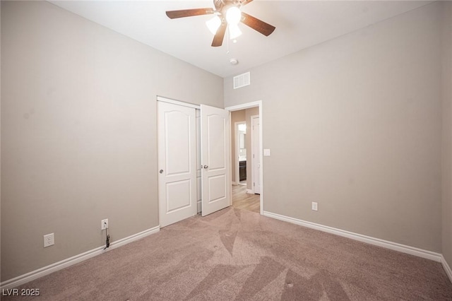 unfurnished bedroom with a closet, light carpet, and ceiling fan