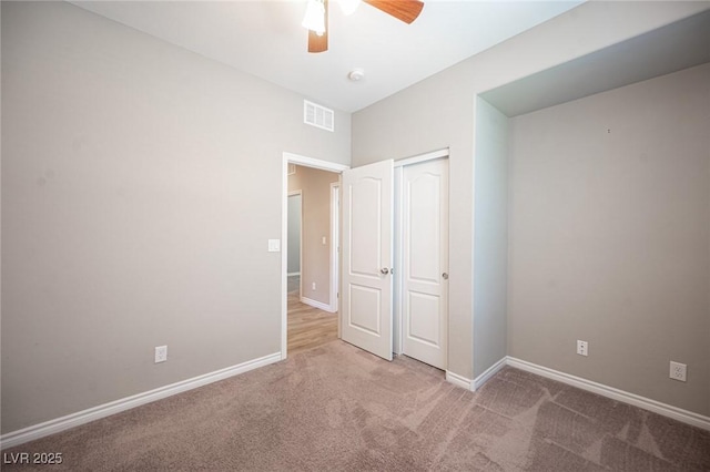 unfurnished bedroom featuring ceiling fan, a closet, and carpet flooring