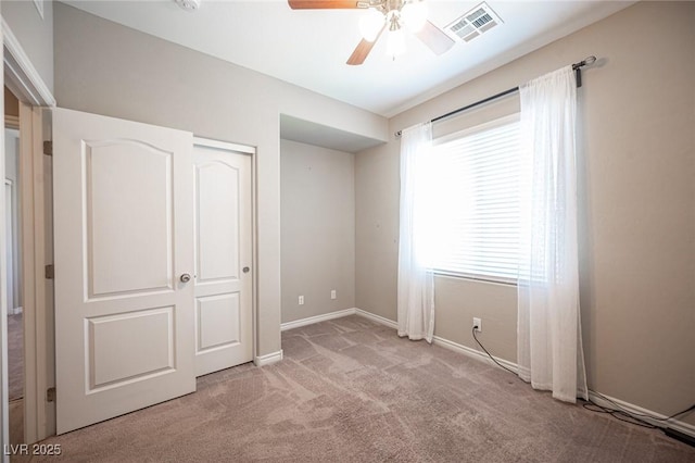 unfurnished bedroom featuring a closet, ceiling fan, and light carpet