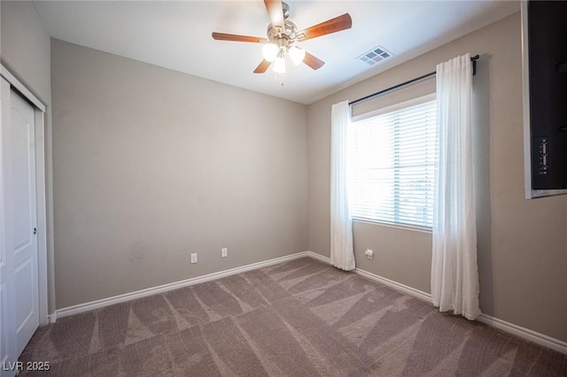 unfurnished room with ceiling fan and carpet flooring