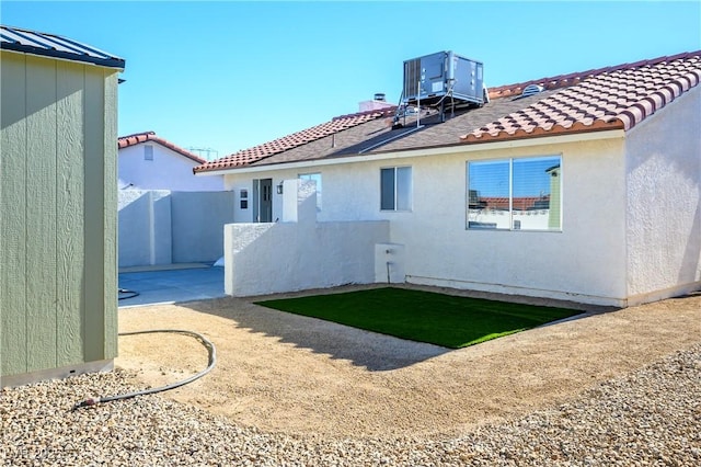 rear view of house featuring central air condition unit and a patio area