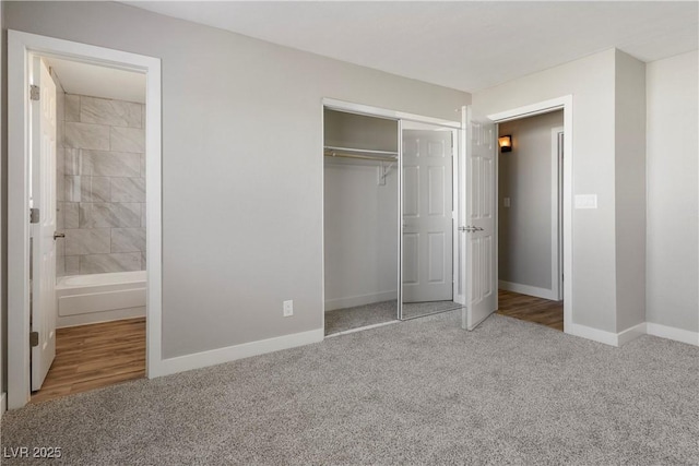 unfurnished bedroom with carpet, ensuite bathroom, and a closet