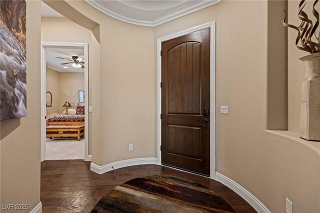 foyer featuring ceiling fan, crown molding, and dark hardwood / wood-style floors