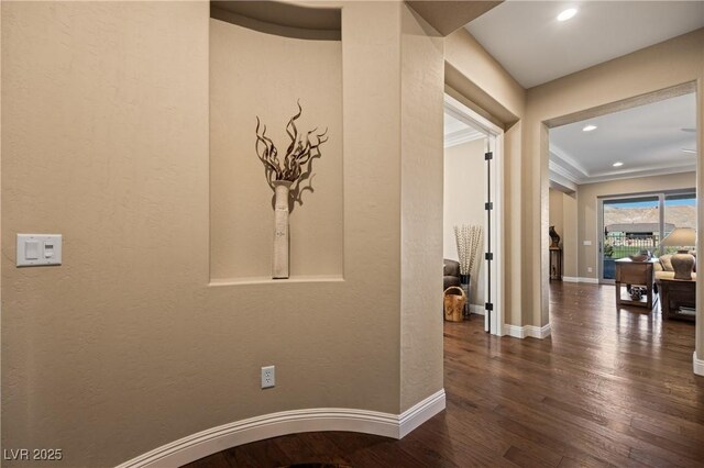 corridor featuring dark wood-type flooring and crown molding