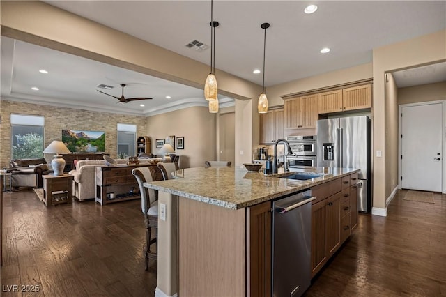 kitchen featuring appliances with stainless steel finishes, ceiling fan, a kitchen island with sink, and sink