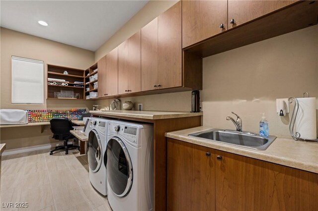 washroom featuring washing machine and dryer, light wood-type flooring, cabinets, and sink