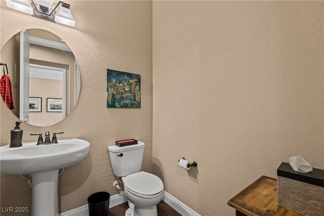 bathroom with hardwood / wood-style floors and toilet